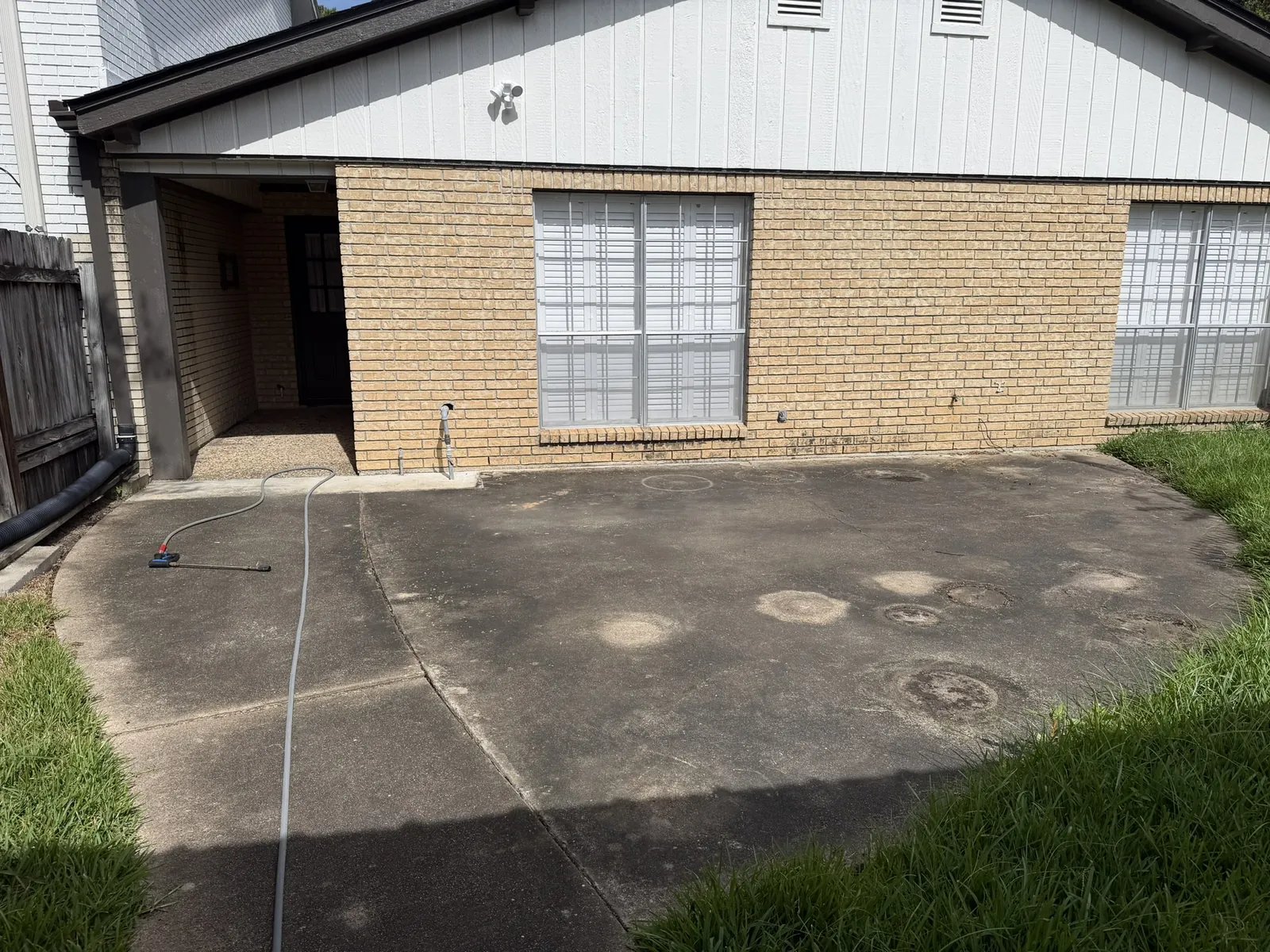 Stained concrete patio before pressure washing in Houston, TX