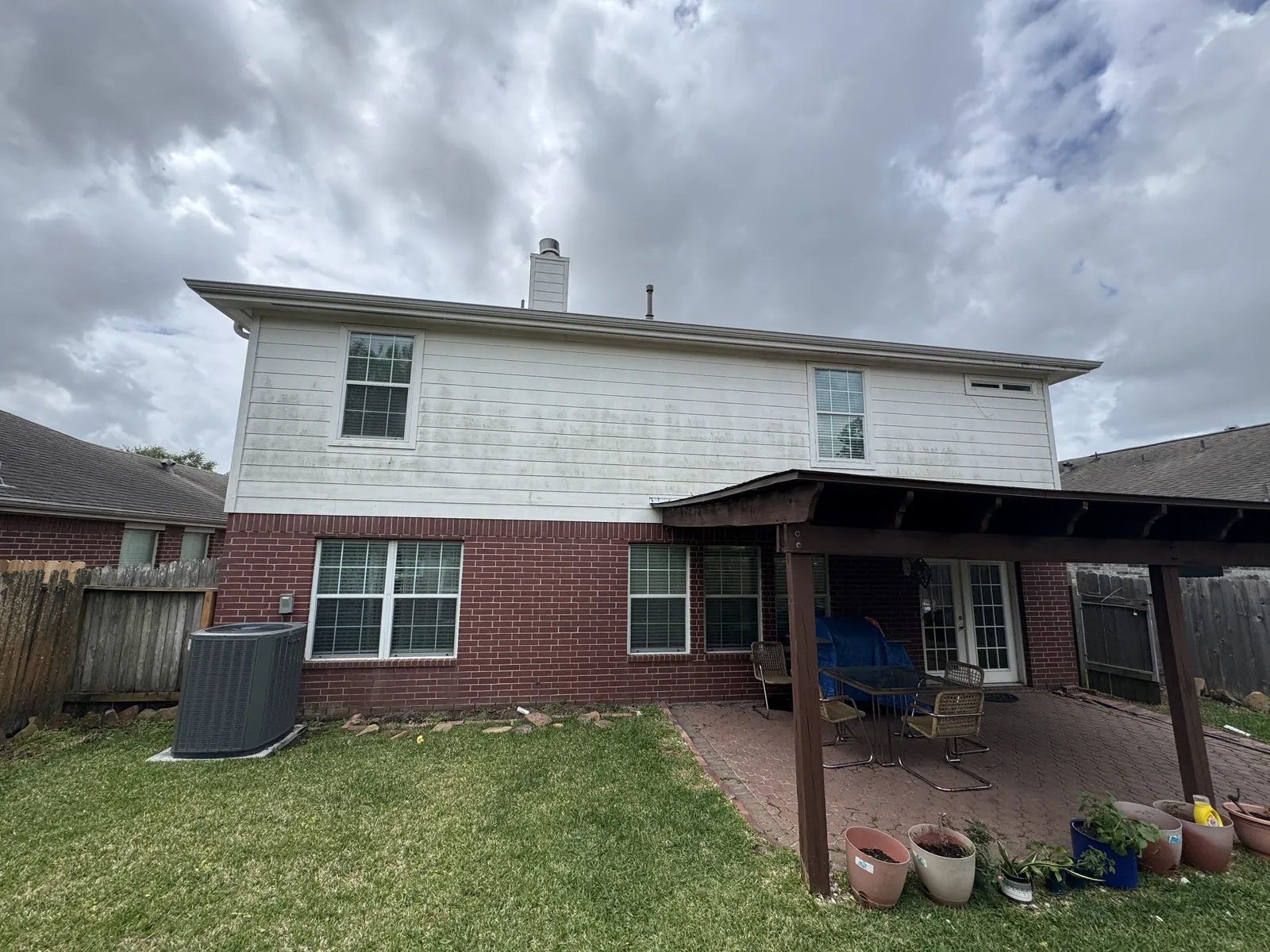 Siding with algae and mildew staining on a Houston, TX home before soft washing