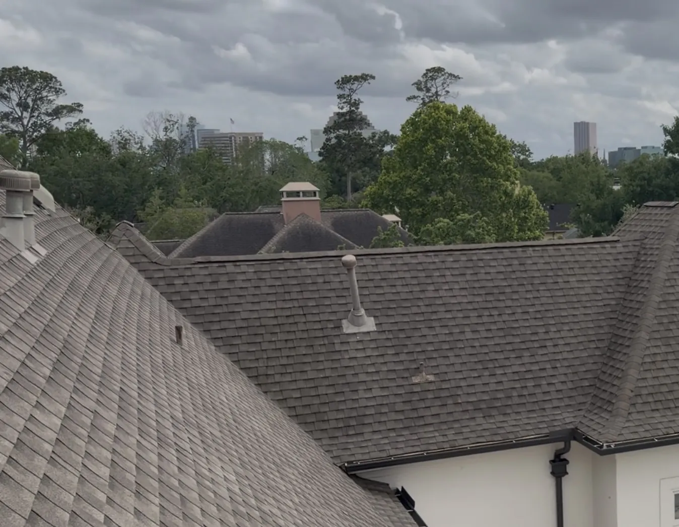 Clean, streak-free asphalt shingle roof with the Houston skyline in the background
